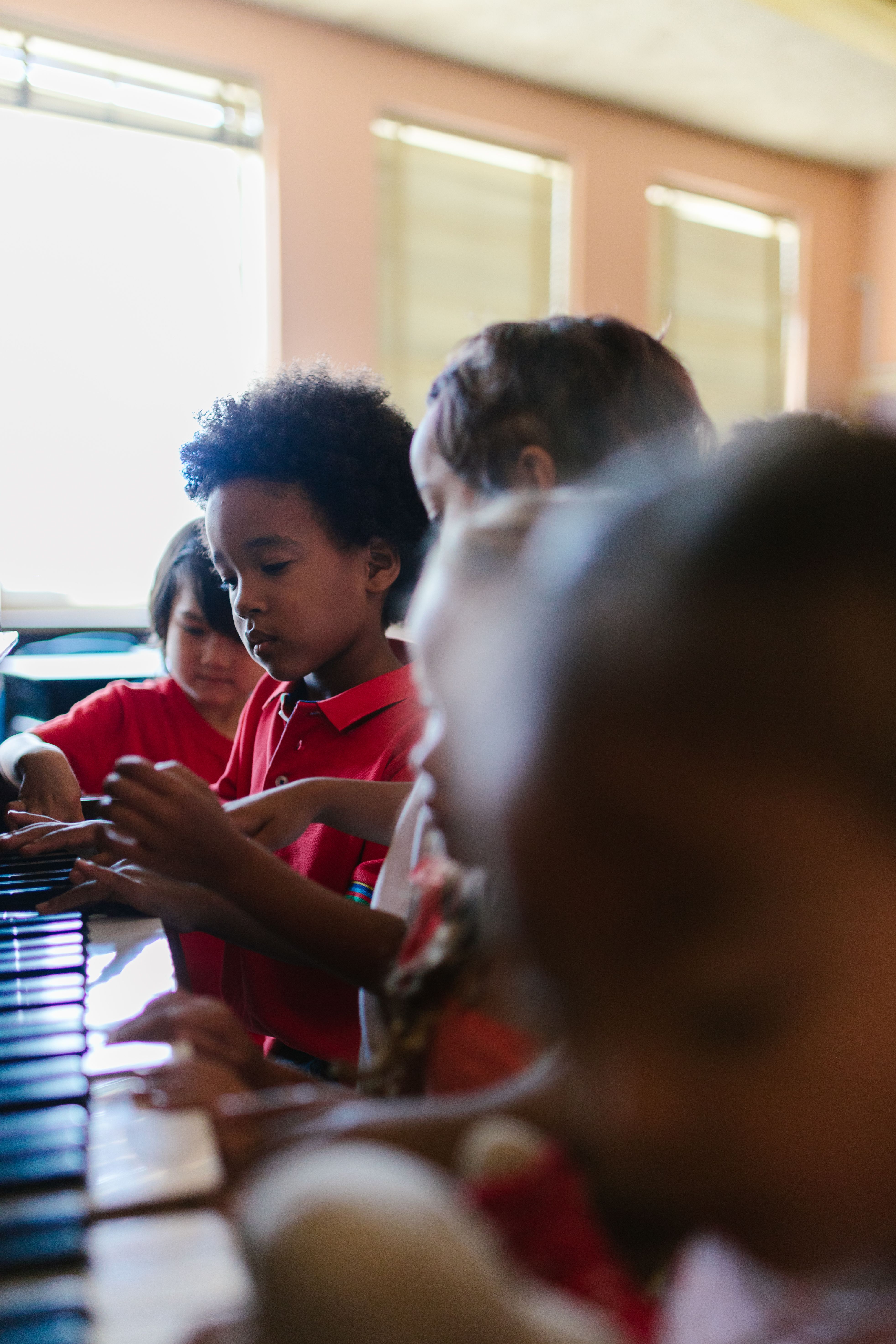 A small group of piano students learning together at digital keyboards