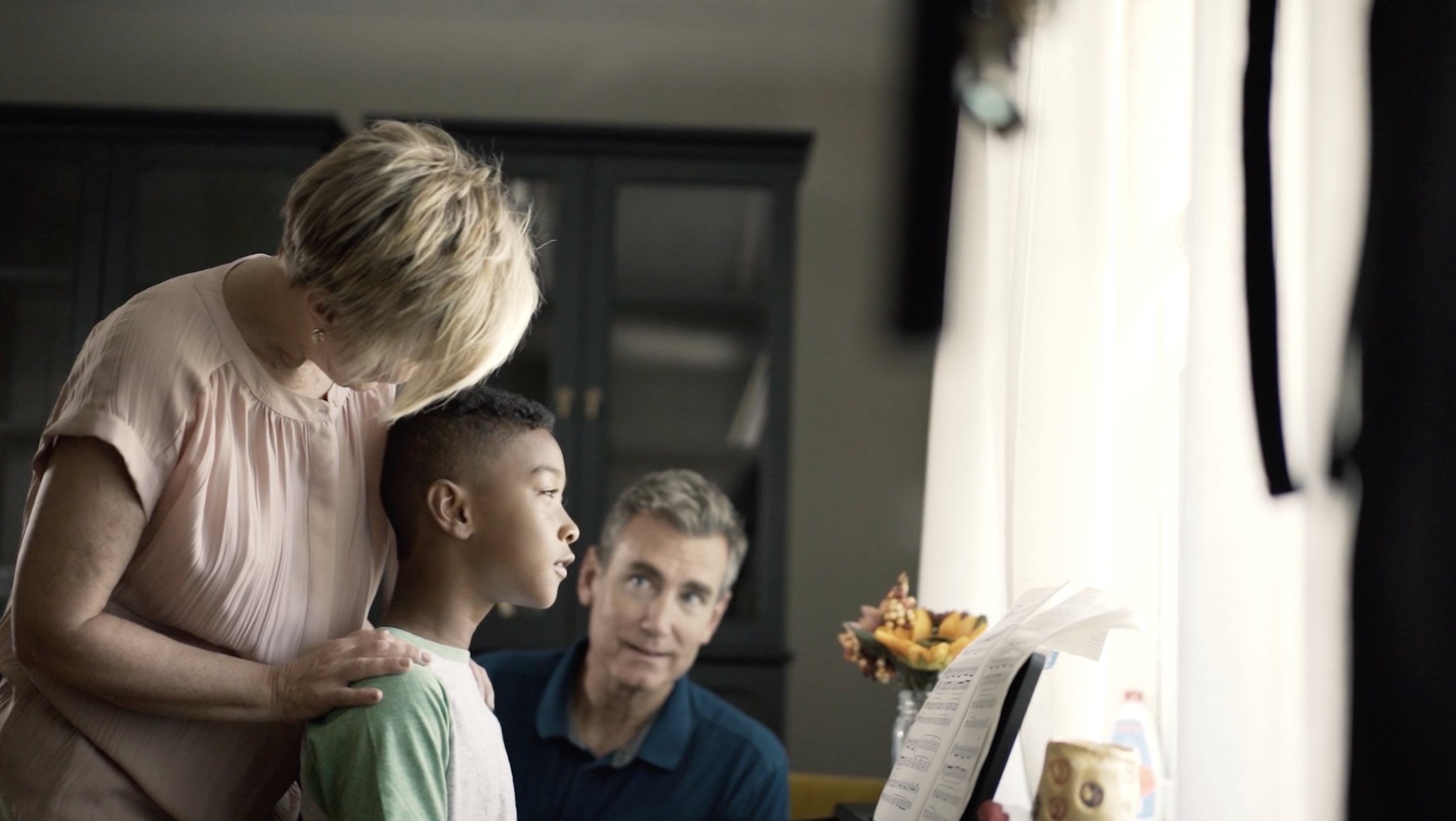 Parent observing a young child during a piano lesson